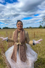 Woman in field with belted brown scarf thumbnail