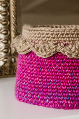Pink basket with tan edging in front of mirror thumbnail