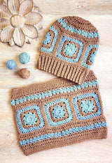 Hat and cowl with granny square motif laid flat on wooden table.  thumbnail