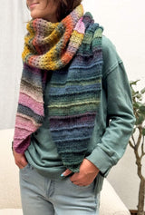 Model wears shawl wrapped around as scarf, in dark red-green, yellow-orange, and pink-violet.  thumbnail