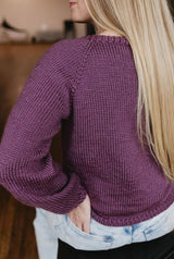 Back view of knit raglan sweater, worn by woman with long blonde hair.  thumbnail