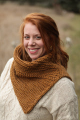 Model wears a golden orange crochet cowl over a cream top, while outdoors.  thumbnail