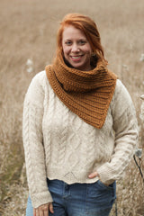 Front view of slanted crochet cowl, worn by red-haired model in cream sweater and jeans.  thumbnail