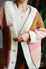 Front view of cardigan with cream button band and blocks of pink, blush, and golden brown.  thumbnail