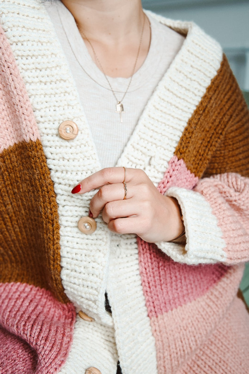 Close up of sleeves and button band on cardigan. 