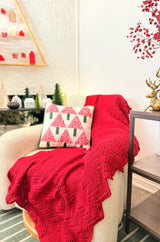Red chevron ripple afghan on a cream chair with Christmas decor. thumbnail