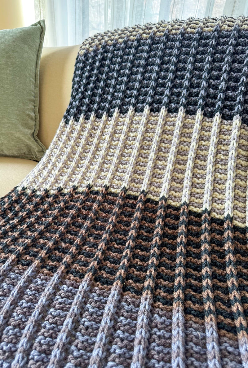 Close up of color blocked striped blanket, showing ridged texture. 