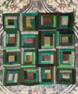 Full view of knit log cabin blanket, laid flat on rug.  thumbnail