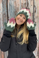 Woman wears hat and mittens in green, cream, and pink, with triangular design.  thumbnail
