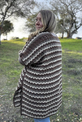 Back view of striped wrap in cream, taupe, and brown, hanging to her knees.  thumbnail