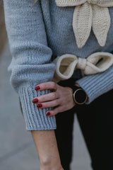 Close up of pale blue sweater cuff showing long wrist ribbing. thumbnail
