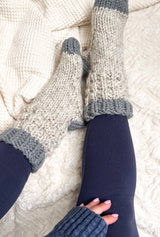 Close up of model's legs in navy leggings, wearing creamy socks with grey toes, heel, and cuff.  thumbnail