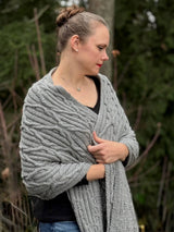 Woman standing outdoors wearing grey cabled knit wrap thumbnail