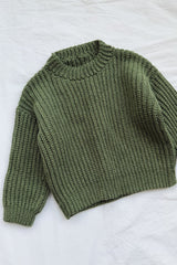 Green crochet child's sweater laid flat on white background.  thumbnail