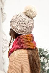 Back view of textured crochet hat in beige with faux fur pompom, and orange pink crochet cowl.  thumbnail