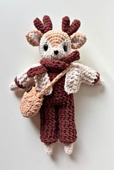 Crochet deer with burgundy jumpsuit, pink jacket, and peach bag.  thumbnail