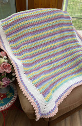 Pastel rainbow crochet blanket draped over armchair.  thumbnail
