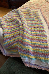 Pastel crochet blanket in white, pink, yellow, green, blue, green, purple, and dark pink.  thumbnail