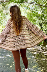 Back view of crochet cardigan, with woman holding bottom corners out to side.  thumbnail