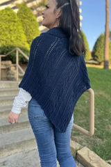 Back view of navy cable knit poncho, worn with jeans and a white long sleeve shirt.  thumbnail