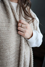 Close up of beige knit scarf showing reverse side of texture pattern.  thumbnail