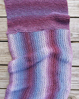 Close up of knit wrap showing two different directions of work, in purple color-changing yarn.  thumbnail