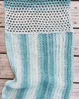 Crochet wrap laid flat on wooden deck showing two textures and two working directions.  thumbnail