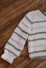 Sweater laid flat on dark wood floor, showing sleeve and right half of body.  thumbnail