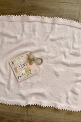 Full view of pale pink knit blanket, showing heart in lower right corner and a picot edge all around.  thumbnail