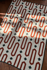 Crochet afghan laid on wooden floor.  thumbnail