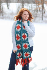 Woman standing in snowy field with scarf draped around neck. It hangs to mid-thigh, with fringe going to knee length.  thumbnail