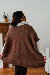 Back view of ruana style poncho, showing smooth texture at the top and bands of garter stitch at the bottom.  thumbnail