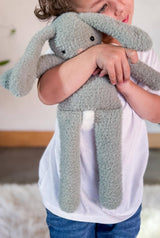 Close up on bunny toy being hugged by small child.  thumbnail