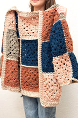 Young woman holds cardigan toward camera, showing seams on the inside.  thumbnail