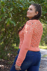Side and back view of crochet cardigan, showing textured lace body. The cardigan is cropped with ribbing at the waist, and has solid sleeves.  thumbnail
