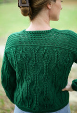 Back view of green crochet cardigan. The upper back is plain, and there are vertical columns of diamond cables down the back below the yoke.  thumbnail