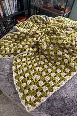 Close up of granny stitch pattern and pointed edge of crochet afghan, in cream and acid green.  thumbnail