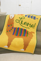 Yellow afghan with large llama motif is laid over couch indoors.  thumbnail