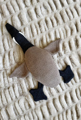 Knit goose toy in the colors of a Canada Goose. It has a tan back and wings, black feet, head and neck, and a white chinstrap.  thumbnail