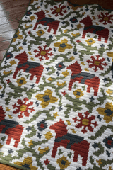 Cropped view of crochet afghan with an all-over pattern of horses, flowers, and vines.  thumbnail