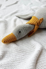 Front view of goose's head, showing orange beak and neck scarf, and black embroidered eyes. The goose's body is a soft grey. thumbnail