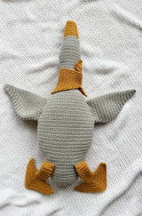 A goose lays on its back! The wings are spread and you can see where the cute orange-yellow legs attach to the body, which is soft grey.  thumbnail