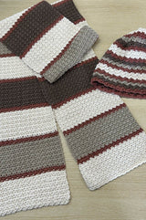 Flat lay of hat and matching scarf, in a textured crochet stitch.  thumbnail