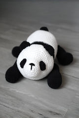 Front view of stuffed panda cub, showing it's four short legs, rounded ears, eye patches and cute nose.  thumbnail