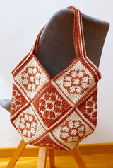 Crochet patchwork bag hands from back of chair, showing striped strap.  thumbnail