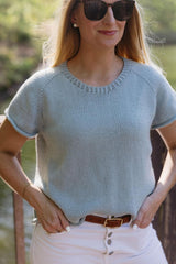 Cropped view of woman wearing knit t-shirt. The top has raglan increases, a ribbed collar, and rolled hems on sleeves and body.  thumbnail
