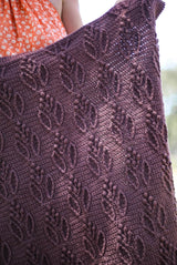 Close up of raised pattern on crochet blanket. The blanket is purple-brown with a leaf and berry pattern.  thumbnail