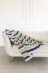 Crochet blanket draped over a cream couch.  thumbnail