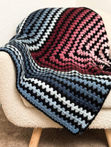 Gradient striped blanket laid over cream armchair.  thumbnail