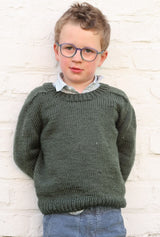 Boy in glasses and blue pants wears a knit green sweater with saddle shoulder construction.  thumbnail